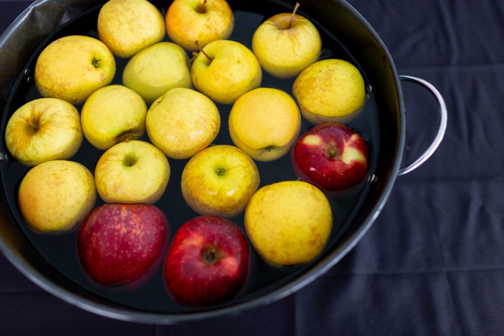 apples submerged in a pot of water