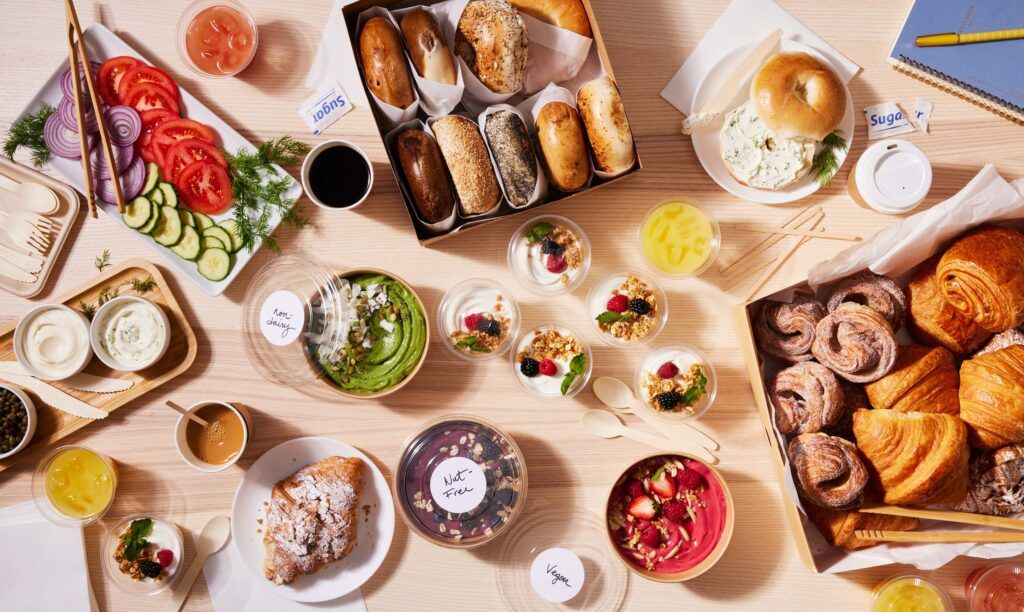 breakfast spread with bagels, acai bowls, and pastries