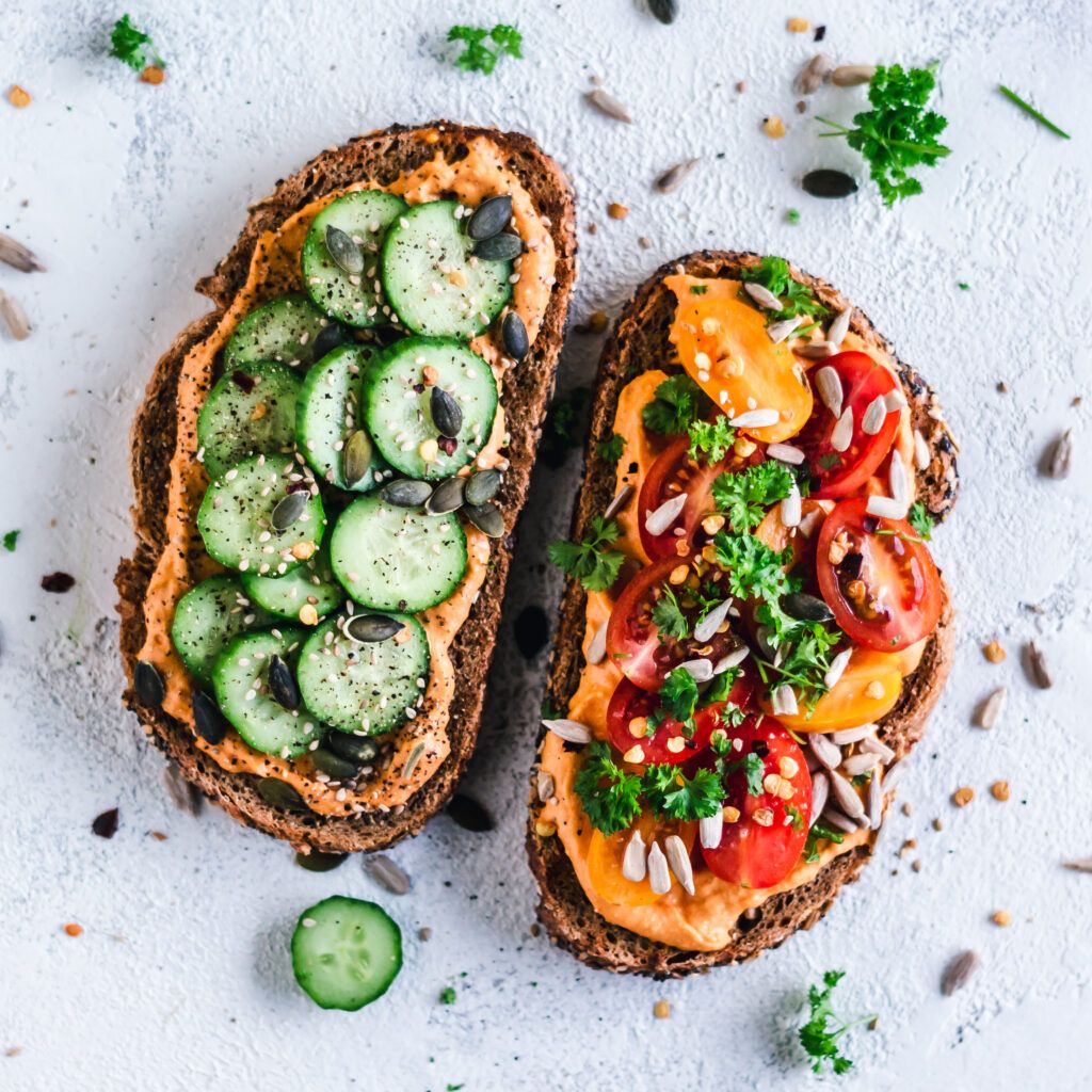 toast with hummus, vegetables, and pumpkin seeds