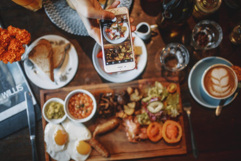 A person taking a photo of a food spread.