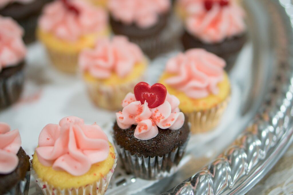 Cupcakes with pink frosting and a heart on top.