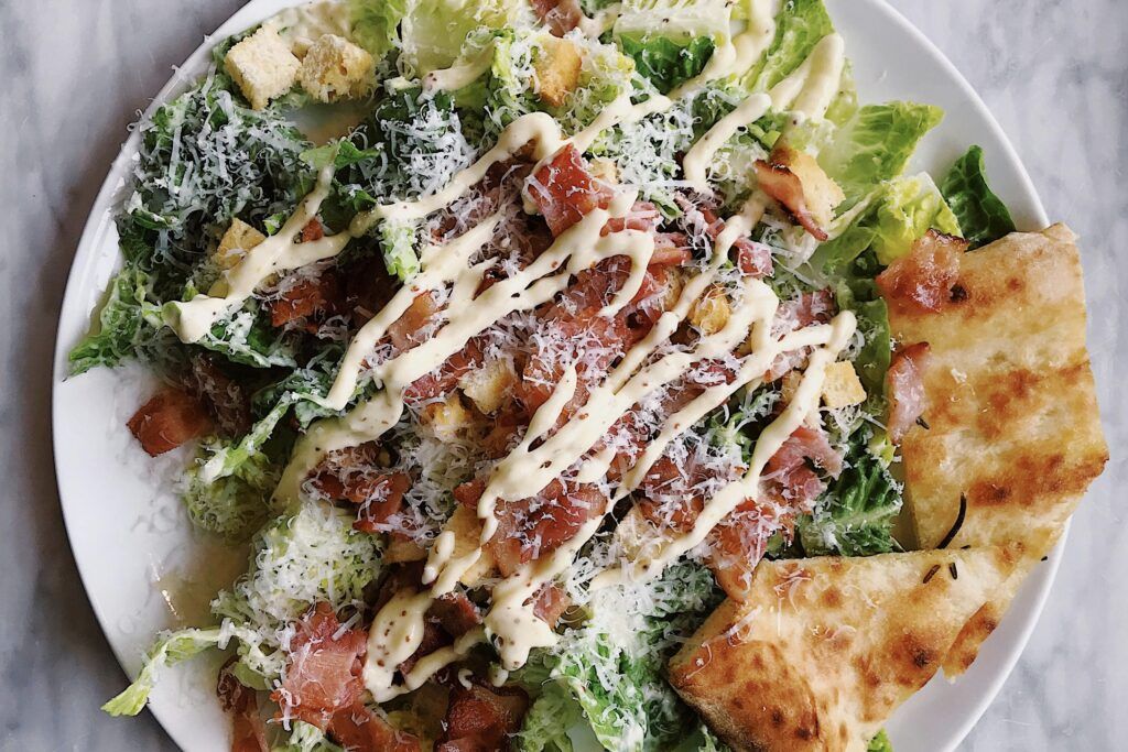 A salad with lettuce, tomato, and croutons. 